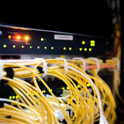 Gelbe Glasfaserkabel sind an einem Netzwerkgerät mit leuchtenden LED-Anzeigen angeschlossen.