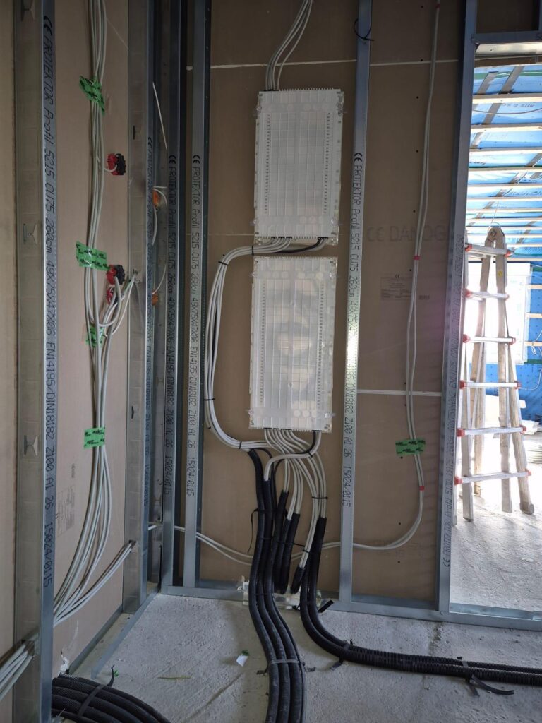 Installation von Metallprofilen und Kabelkanälen in einem Rohbau mit verdrahteten Verteilerkästen.